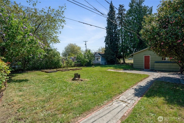 view of yard featuring fence and an outbuilding