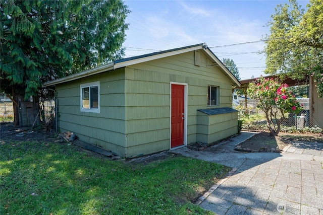 view of outbuilding featuring fence