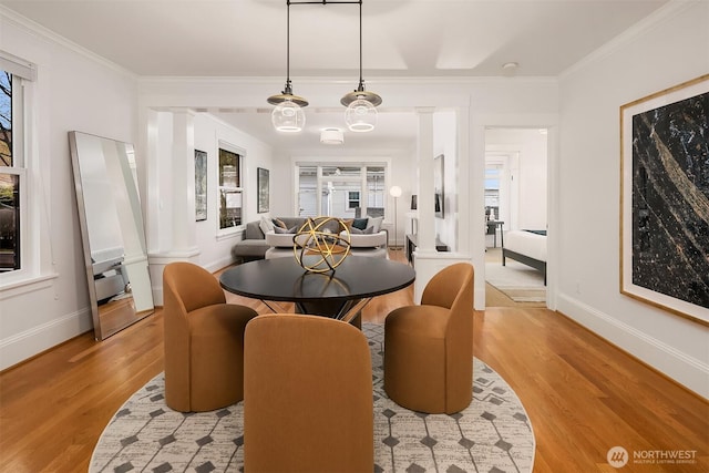 dining space with light wood-style flooring, crown molding, and baseboards