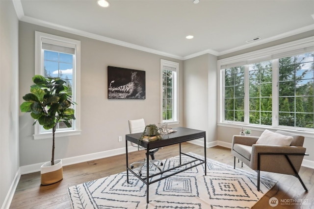 home office with ornamental molding, visible vents, light wood-style flooring, and a healthy amount of sunlight