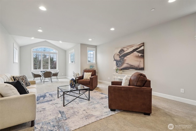 living area featuring baseboards, plenty of natural light, light carpet, and lofted ceiling