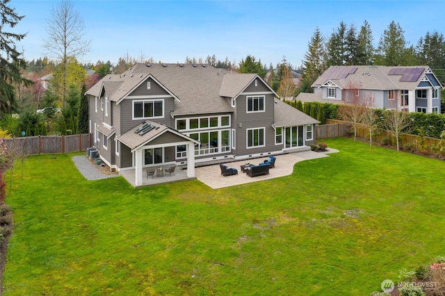 back of property with a lawn, cooling unit, a patio area, a fenced backyard, and a shingled roof