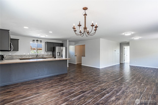 kitchen featuring open floor plan, light countertops, stainless steel fridge, and a peninsula