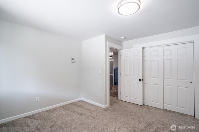 unfurnished bedroom featuring carpet, a closet, and baseboards