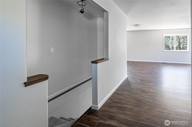 hallway featuring baseboards and dark wood-style floors