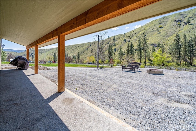 view of patio / terrace featuring a fire pit and a mountain view