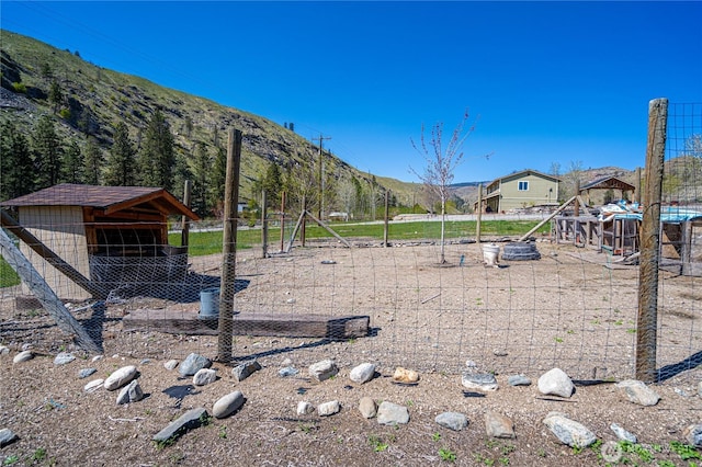 view of play area featuring exterior structure, a mountain view, and an outbuilding