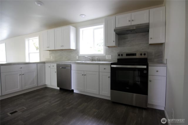 kitchen featuring visible vents, under cabinet range hood, appliances with stainless steel finishes, and dark wood-type flooring