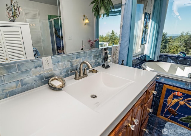 full bath with vanity, tasteful backsplash, a stall shower, and a healthy amount of sunlight