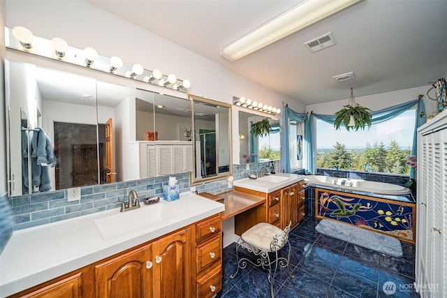 bathroom with decorative backsplash, a sink, a garden tub, visible vents, and two vanities
