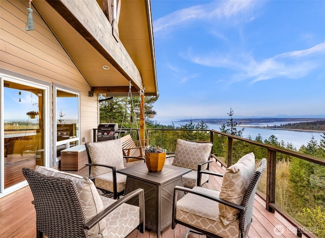 wooden terrace featuring a water view and a grill