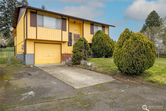 1023 S 88th St, Tacoma, WA 98444 - raised ranch with a garage, fence, a front lawn, a gate, and driveway