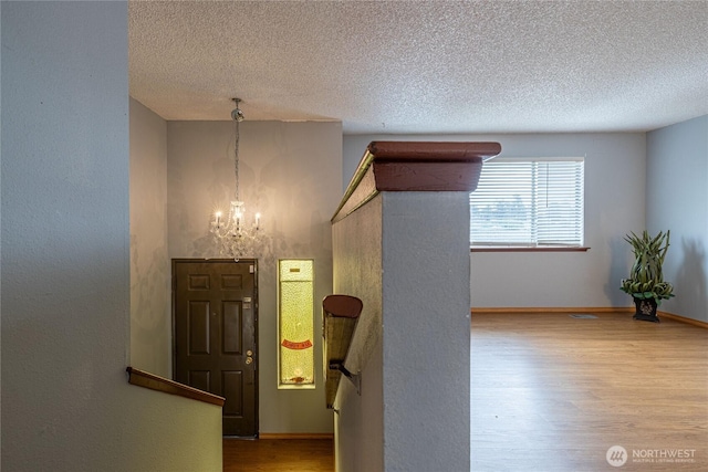1023 S 88th St, Tacoma, WA 98444 - interior space with a notable chandelier, baseboards, a textured ceiling, and wood finished floors