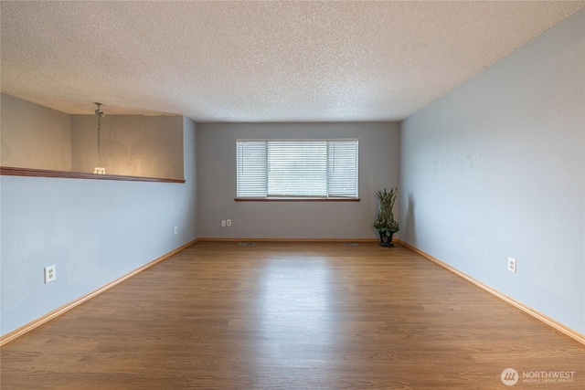 1023 S 88th St, Tacoma, WA 98444 - empty room featuring baseboards, wood finished floors, and a textured ceiling