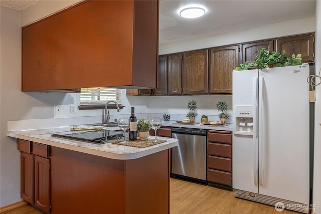 1023 S 88th St, Tacoma, WA 98444 - kitchen with light countertops, light wood-type flooring, stainless steel dishwasher, white refrigerator with ice dispenser, and stovetop