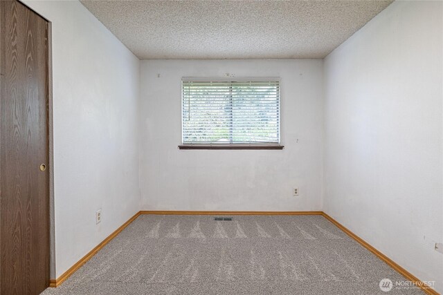 1023 S 88th St, Tacoma, WA 98444 - empty room with carpet floors, baseboards, and a textured ceiling
