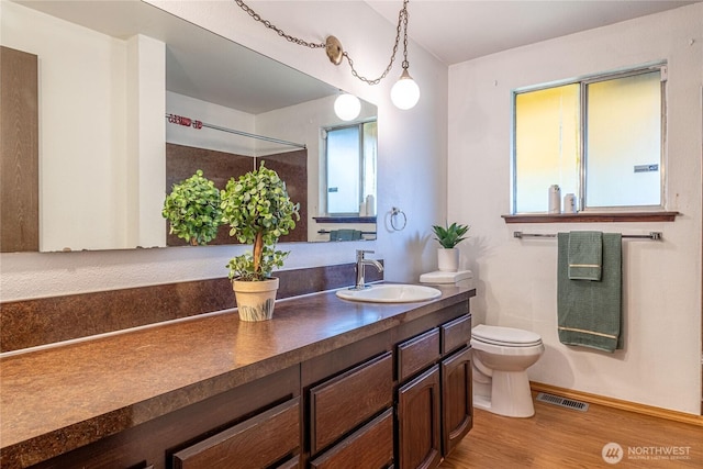 1023 S 88th St, Tacoma, WA 98444 - bathroom with vanity, visible vents, toilet, wood finished floors, and baseboards