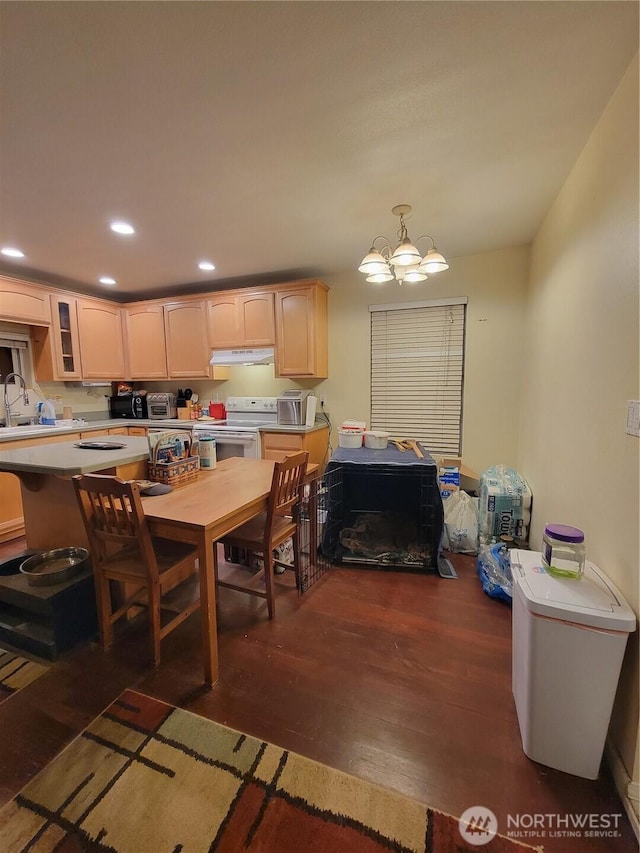 dining space featuring wood finished floors, a notable chandelier, a toaster, and recessed lighting