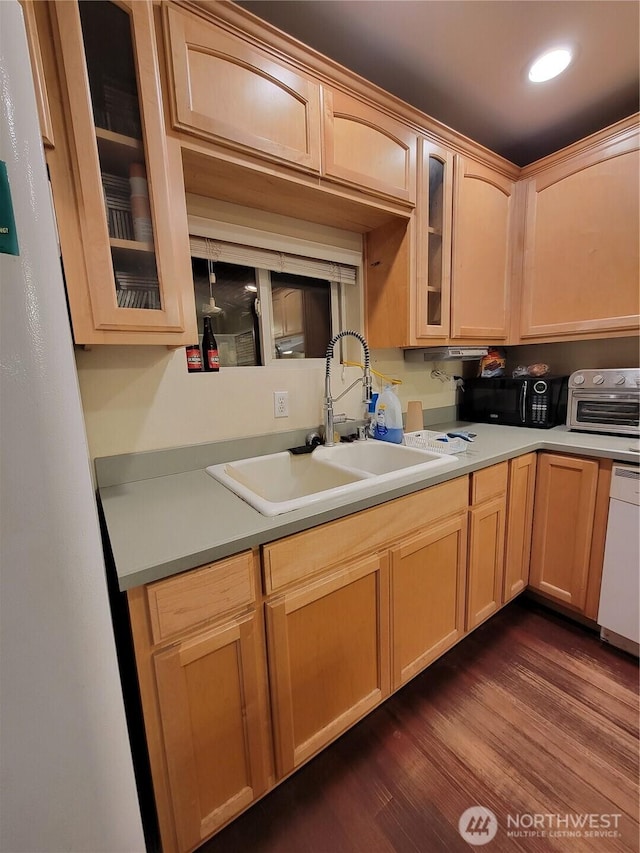 kitchen featuring dark wood-style flooring, black microwave, glass insert cabinets, dishwasher, and a sink