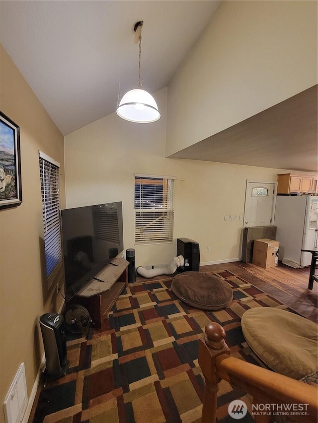 carpeted bedroom with white refrigerator with ice dispenser, high vaulted ceiling, baseboards, and visible vents