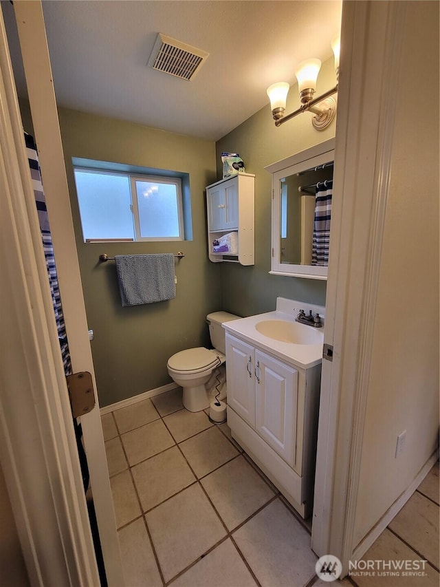 bathroom featuring visible vents, baseboards, toilet, vanity, and tile patterned floors