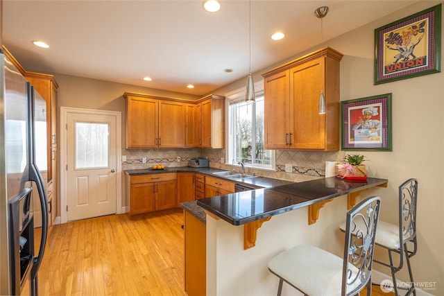 660 Parkside Pl, Blaine, WA 98230 - kitchen with a peninsula, brown cabinets, stainless steel fridge with ice dispenser, and light wood-type flooring