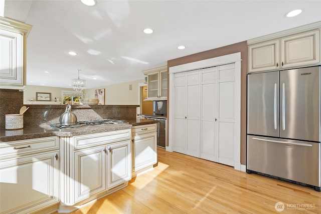 kitchen featuring recessed lighting, light wood-style floors, cream cabinets, and appliances with stainless steel finishes