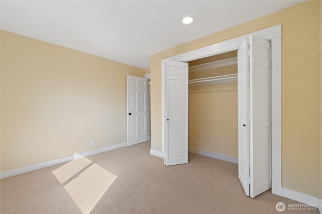 unfurnished bedroom featuring a closet, recessed lighting, light colored carpet, and baseboards