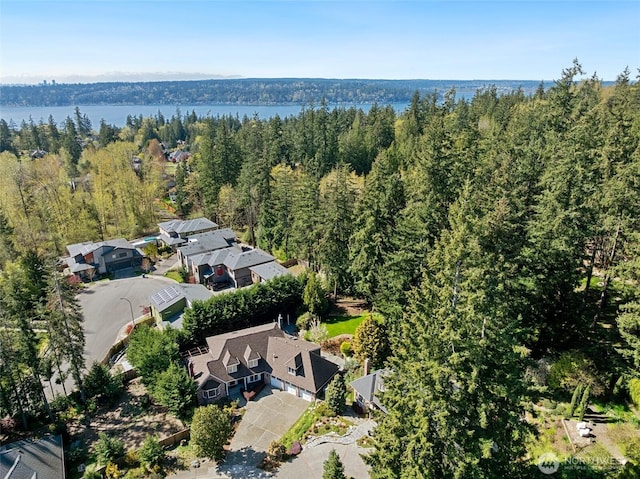 birds eye view of property featuring a forest view, a residential view, and a water view