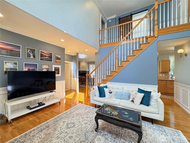 861 Kirner Rd, Sequim, WA 98382 - living room featuring ornamental molding, wood finished floors, stairs, a decorative wall, and wainscoting