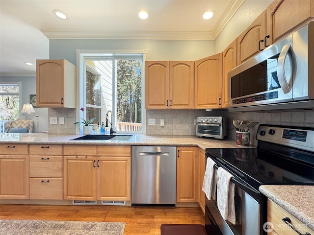 861 Kirner Rd, Sequim, WA 98382 - kitchen featuring appliances with stainless steel finishes, a sink, light brown cabinets, crown molding, and decorative backsplash