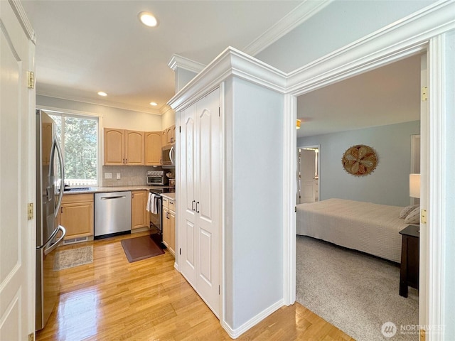 861 Kirner Rd, Sequim, WA 98382 - kitchen with appliances with stainless steel finishes, light brown cabinetry, crown molding, light countertops, and light wood-style flooring