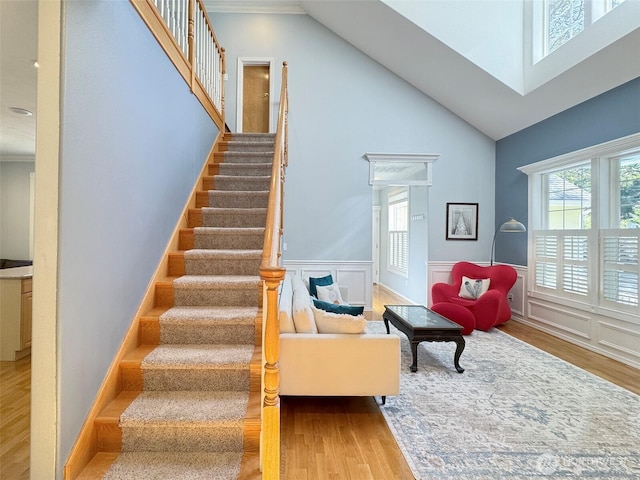 861 Kirner Rd, Sequim, WA 98382 - staircase featuring wood finished floors, high vaulted ceiling, wainscoting, and crown molding