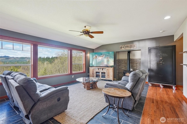 14900 NE Critter Hill Dr, Amboy, WA 98601 - living room featuring ceiling fan, a wood stove, vaulted ceiling, and baseboards