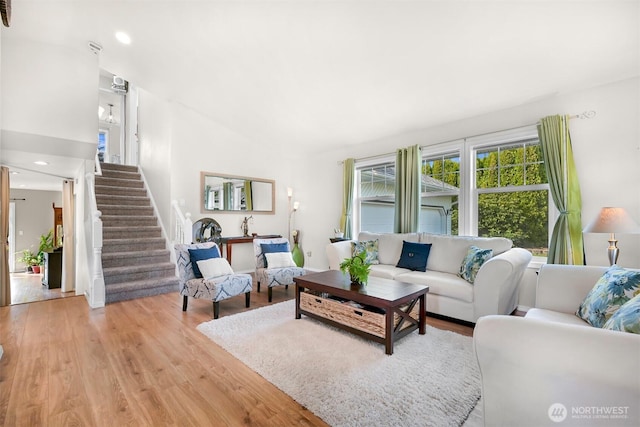 living room with light wood-type flooring, recessed lighting, and stairs
