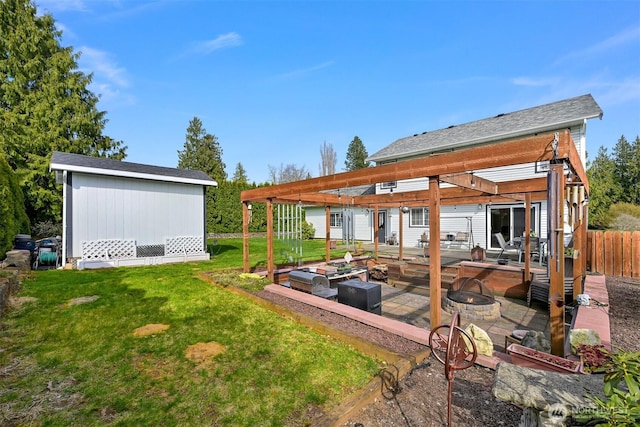 view of yard featuring a pergola, a patio area, an outdoor fire pit, an outbuilding, and fence