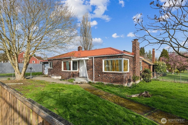 201 S 60th St, Tacoma, WA 98408 - view of front of house featuring a tiled roof, a fenced backyard, a front yard, brick siding, and a chimney