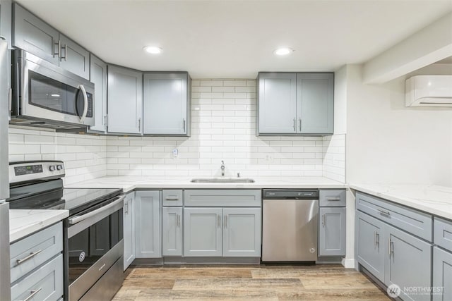 201 S 60th St, Tacoma, WA 98408 - kitchen with gray cabinetry, appliances with stainless steel finishes, a wall mounted air conditioner, and a sink