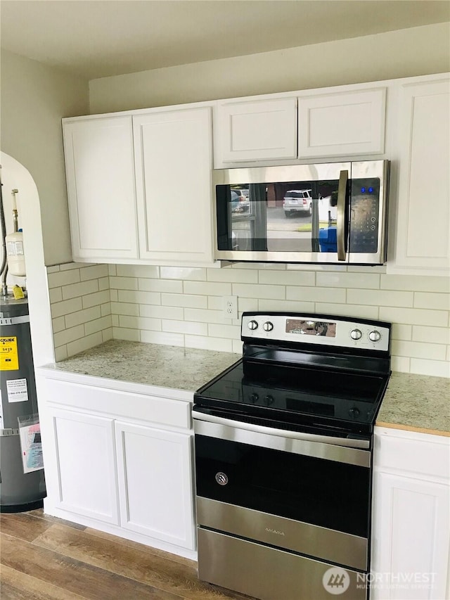 201 S 60th St, Tacoma, WA 98408 - kitchen with white cabinets, electric water heater, and stainless steel appliances