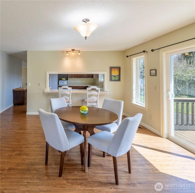 dining area featuring baseboards and wood finished floors