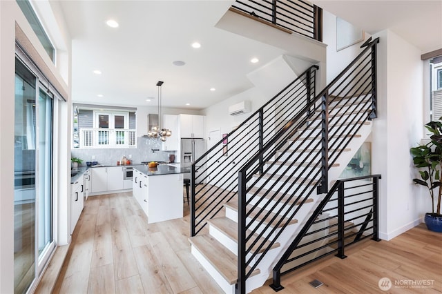 3111 Queen Anne Ave N, Seattle, WA 98119 - stairway with recessed lighting, wood finished floors, and a wall unit AC