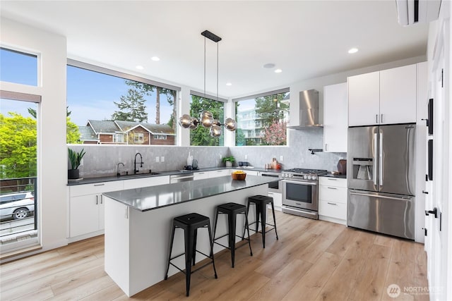 3111 Queen Anne Ave N, Seattle, WA 98119 - kitchen with dark countertops, appliances with stainless steel finishes, wall chimney exhaust hood, and a sink
