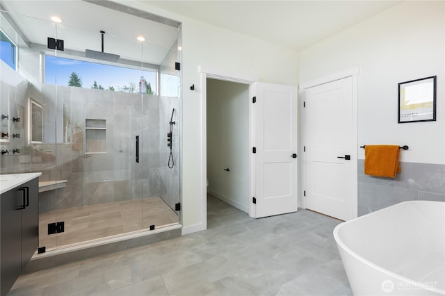 3111 Queen Anne Ave N, Seattle, WA 98119 - full bathroom featuring tile walls, a shower stall, a freestanding tub, and vanity
