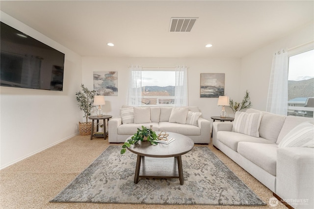 carpeted living room with recessed lighting, baseboards, visible vents, and a wealth of natural light