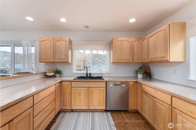 kitchen with light brown cabinetry, dishwasher, a sink, and plenty of natural light