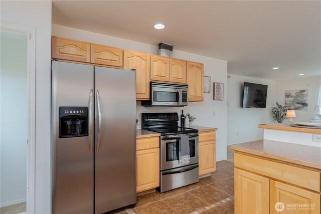 kitchen with light brown cabinets, dark tile patterned floors, light countertops, appliances with stainless steel finishes, and recessed lighting