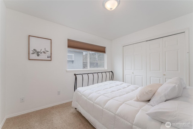 carpeted bedroom featuring a closet and baseboards