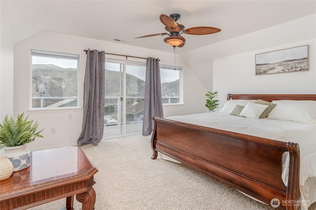 bedroom featuring a mountain view, visible vents, access to exterior, lofted ceiling, and carpet
