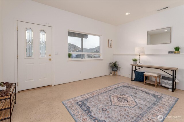 foyer entrance with visible vents, recessed lighting, and speckled floor
