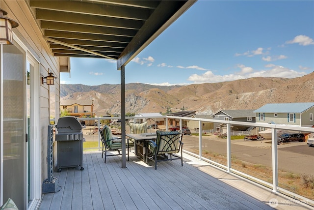 wooden deck featuring a grill, a mountain view, and a residential view